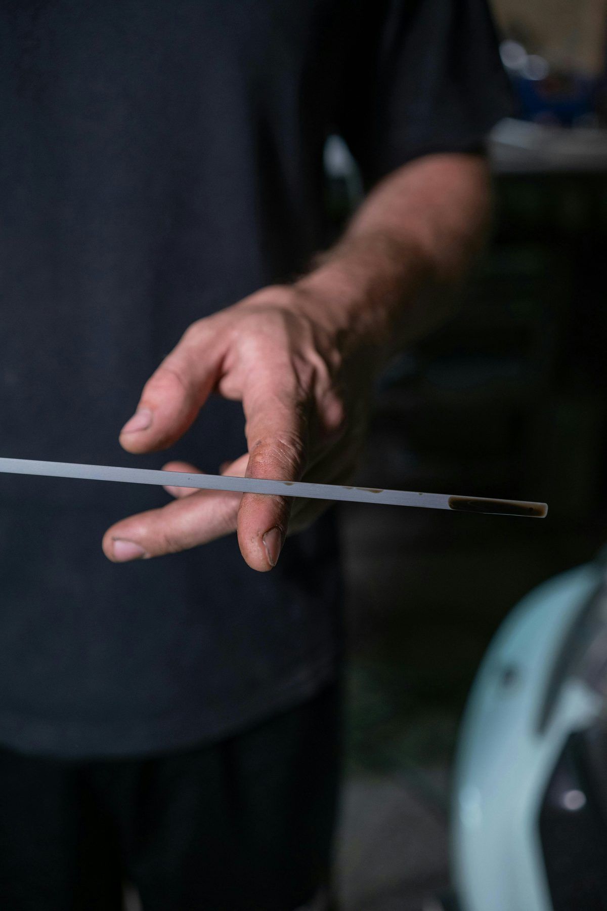 Driver checking engine oil with a dipstick